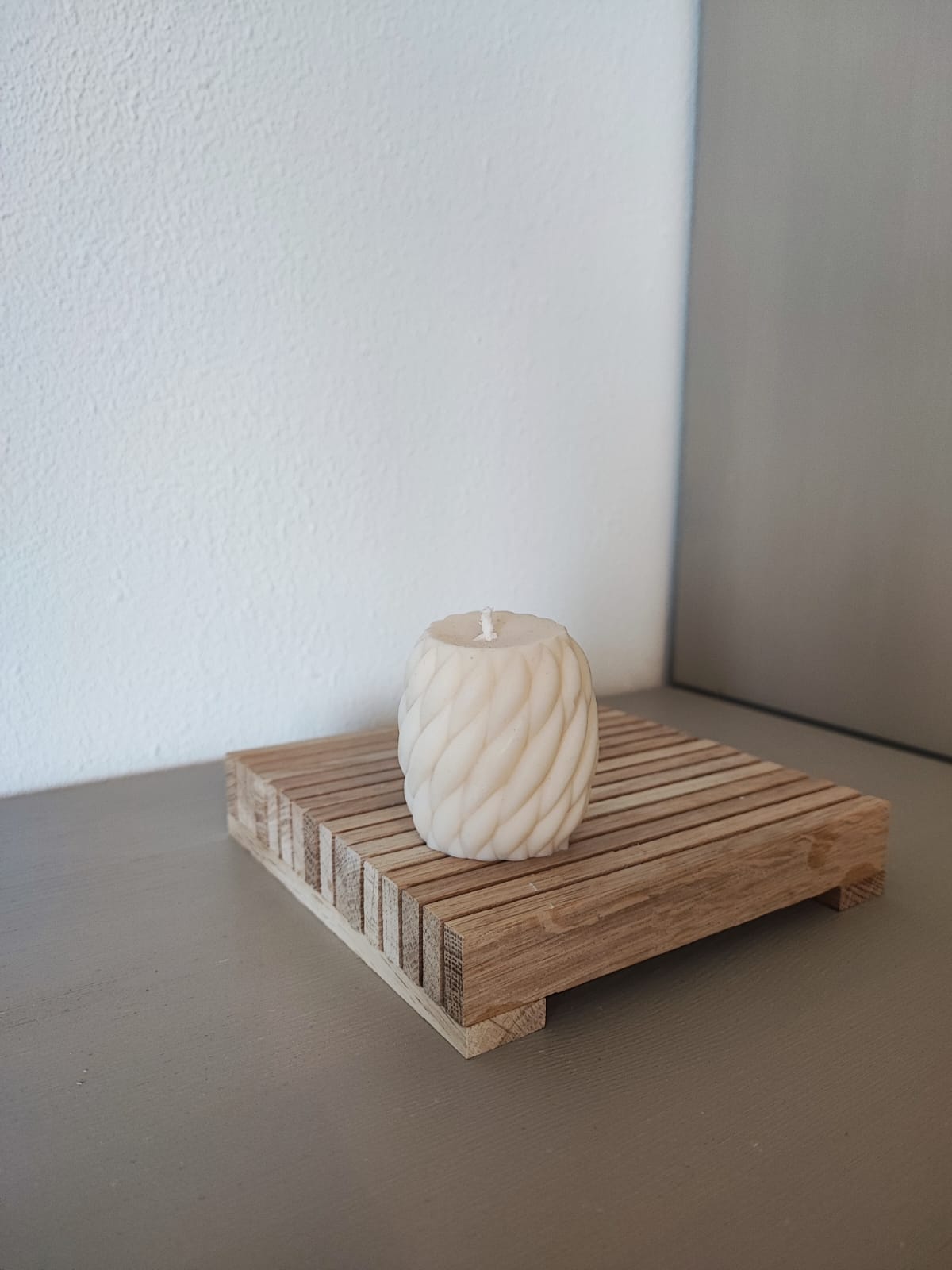 Rapswachskerze_handgegossen_Wollknaeul_mini_weiss_Frontansicht_auf_Holtbrett
