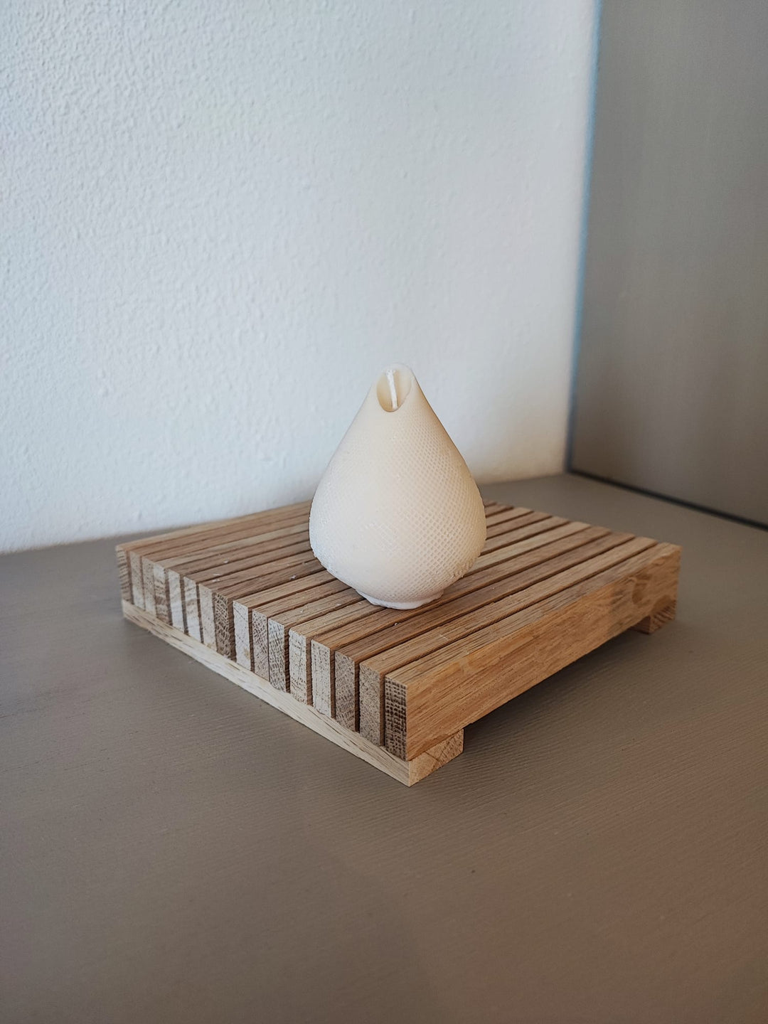 Rapswachskerze_handgegossen_Birne_Willi_weiss_Frontansicht_auf_Holzbrett