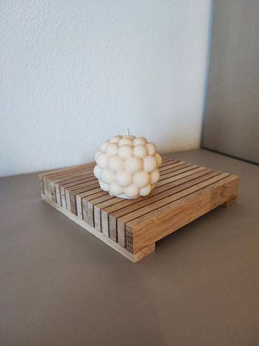 Rapswachskerze_handgegossen_Bubblekugel_weiss_auf_Holzbrett_Frontansicht