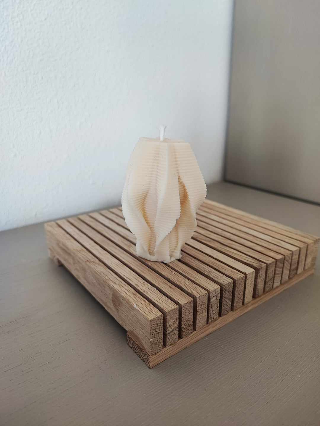 Rapswachskerze_handgegossen_Faechersaeule_weiss_Frontansicht_auf_Holzbrett