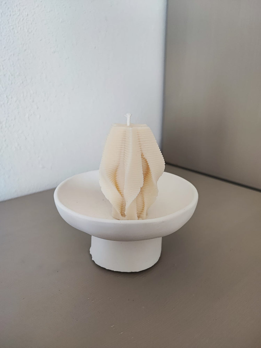 Rapswachskerze_handgegossen_Faechersaeule_weiss_Frontansicht_auf_hoher_schale