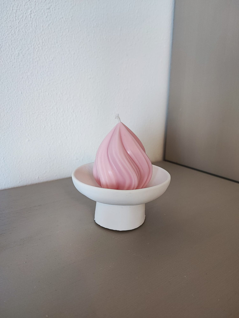 Rapswachskerze_handgegossen_Konfekt_rosa_auf_hoher_schale_frontansicht