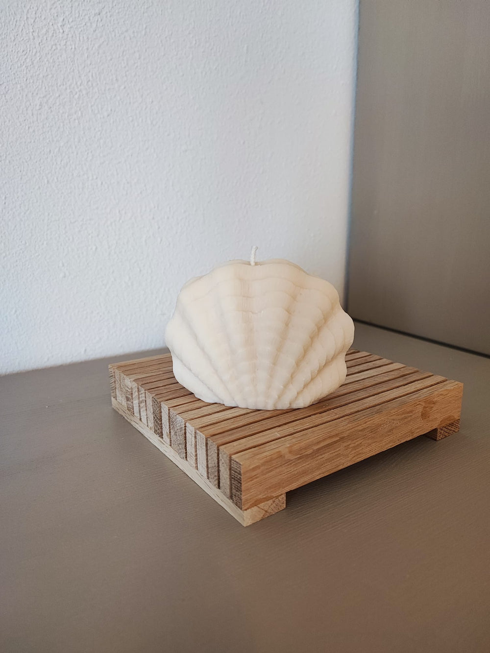 Rapswachskerze_handgegossen_Miesmuschel_weiss_Frontansicht_auf_Holzbrett