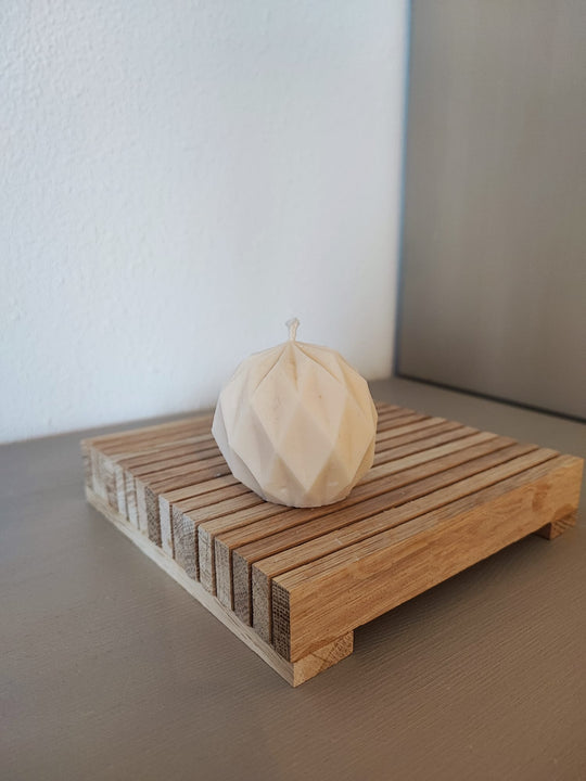 Rapswachskerze_handgegossen_Netzkugel_weiss_Frontansicht_auf_Holzbrett