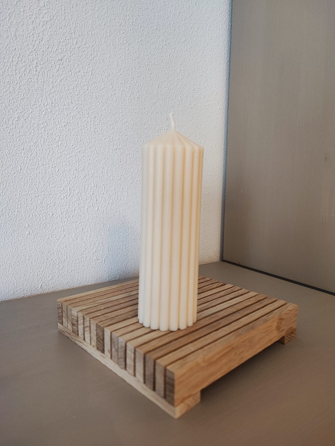 Rapswachskerze_handgegossen_Princess_schmal_weiss_auf_Holzbrett_Frontansicht