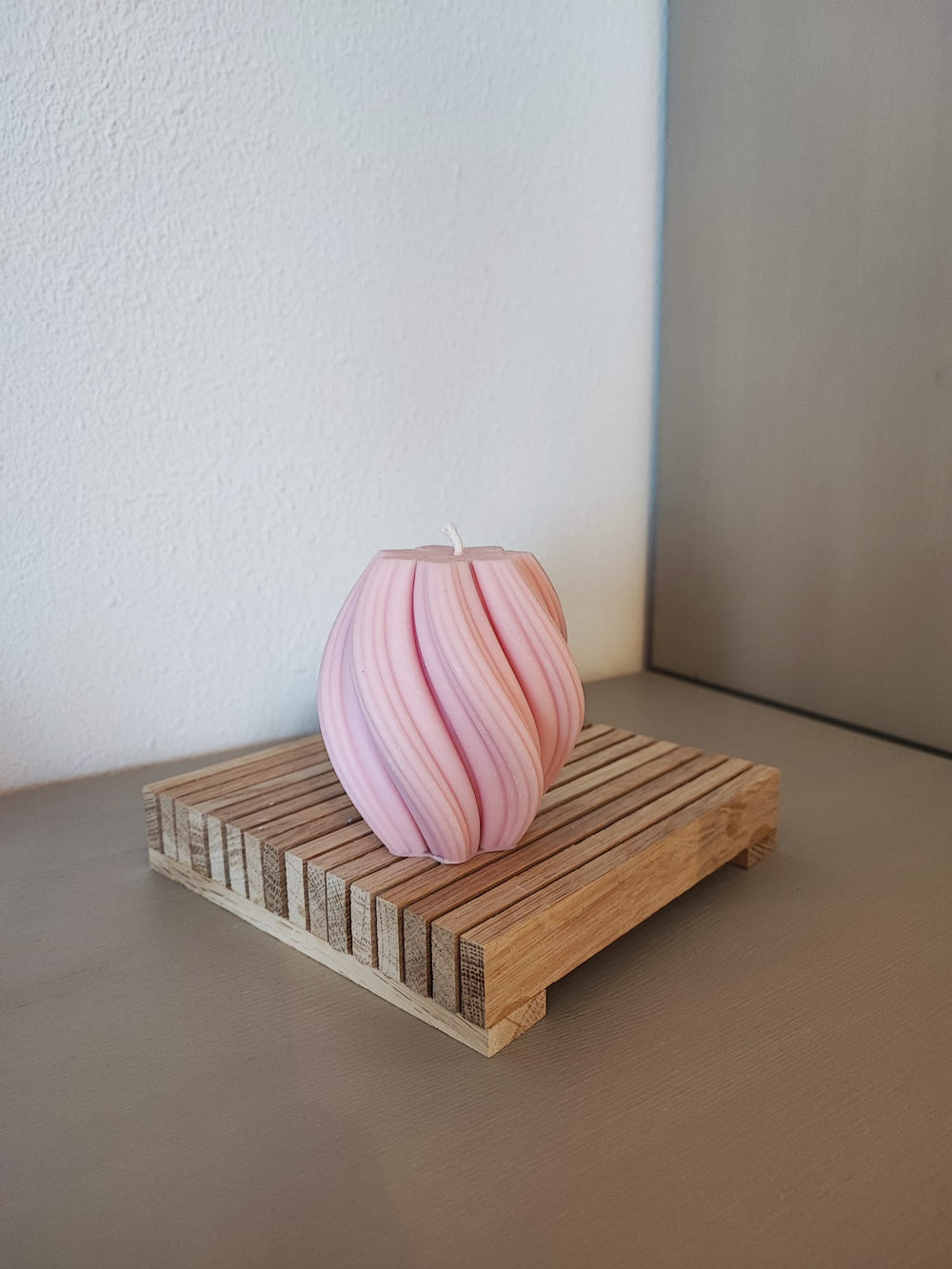 Rapswachskerze_handgegossen_Queen_mittel_rosa_auf_Holzbrett_Frontansicht