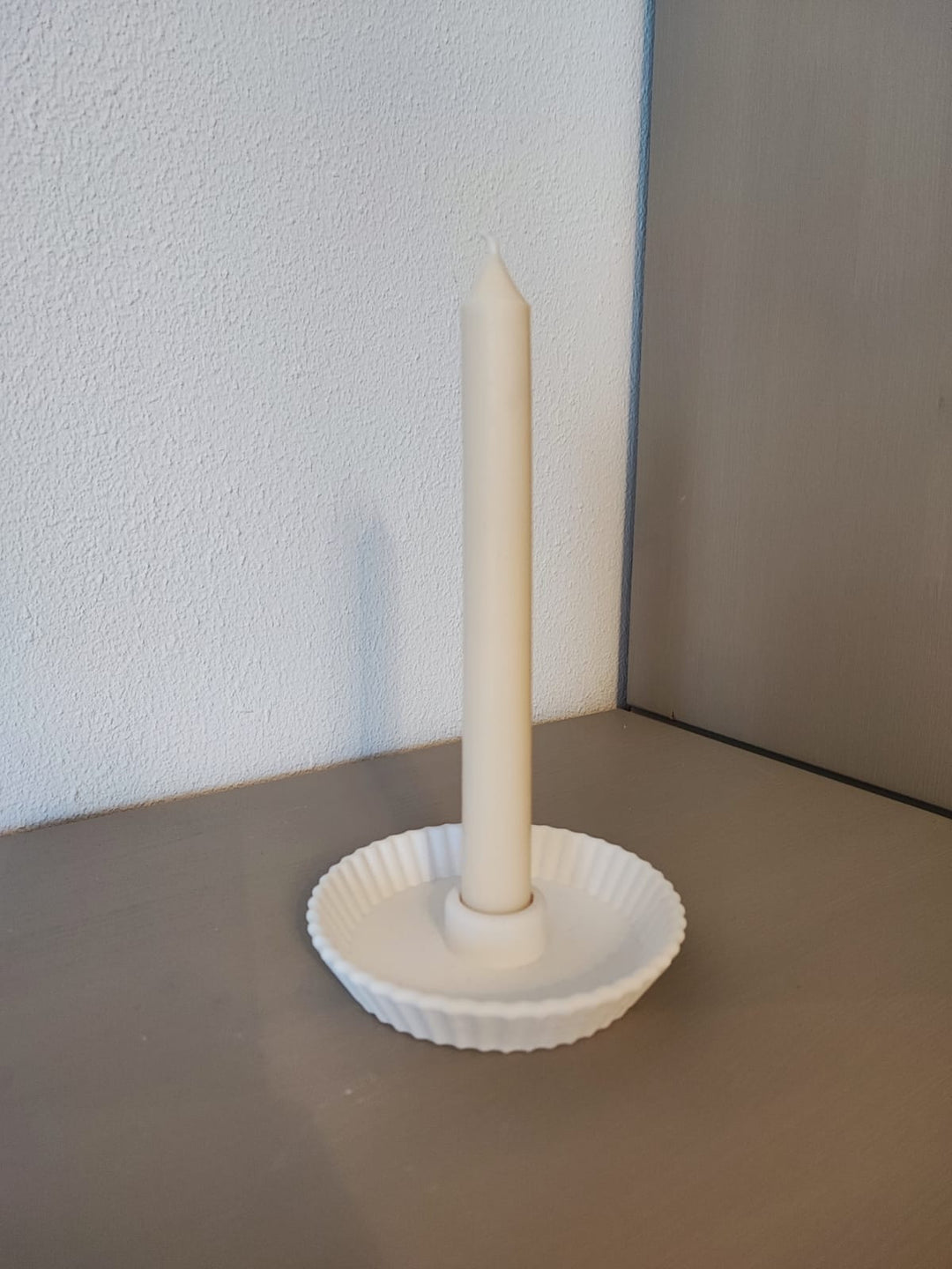 Rapswachskerze_handgegossen_Stabkerze_Mia_weiss_in_Muschel_Kerzenhalter_Frontansicht