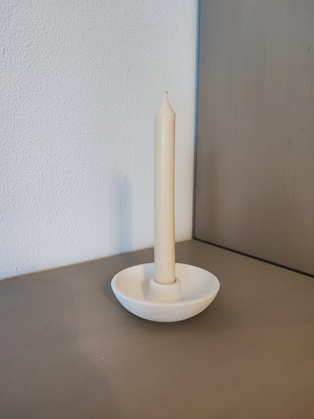 Rapswachskerze_handgegossen_Stabkerze_Mia_weiss_in_Schale_Kerzenhalter_Frontansicht