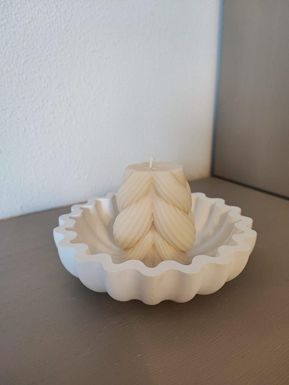 Rapswachskerze_handgegossen_Strickknaeul_weiss_in_Muschelschale_Frontansicht