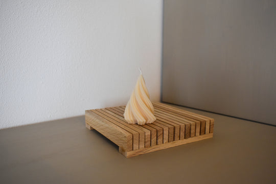 Rapswachskerze_handgegossen_Tannenbaum_gedreht_klein_weiss_Frontansicht_auf_Holzbrett