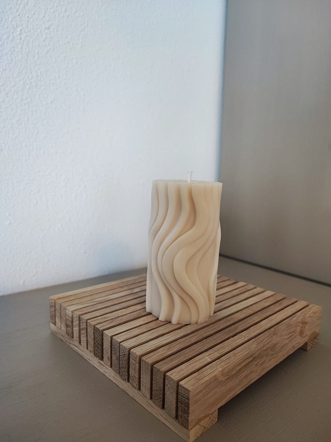 Rapswachskerze_handgegossen_Wave_gross_weiss_frontansicht_auf_holzbrett