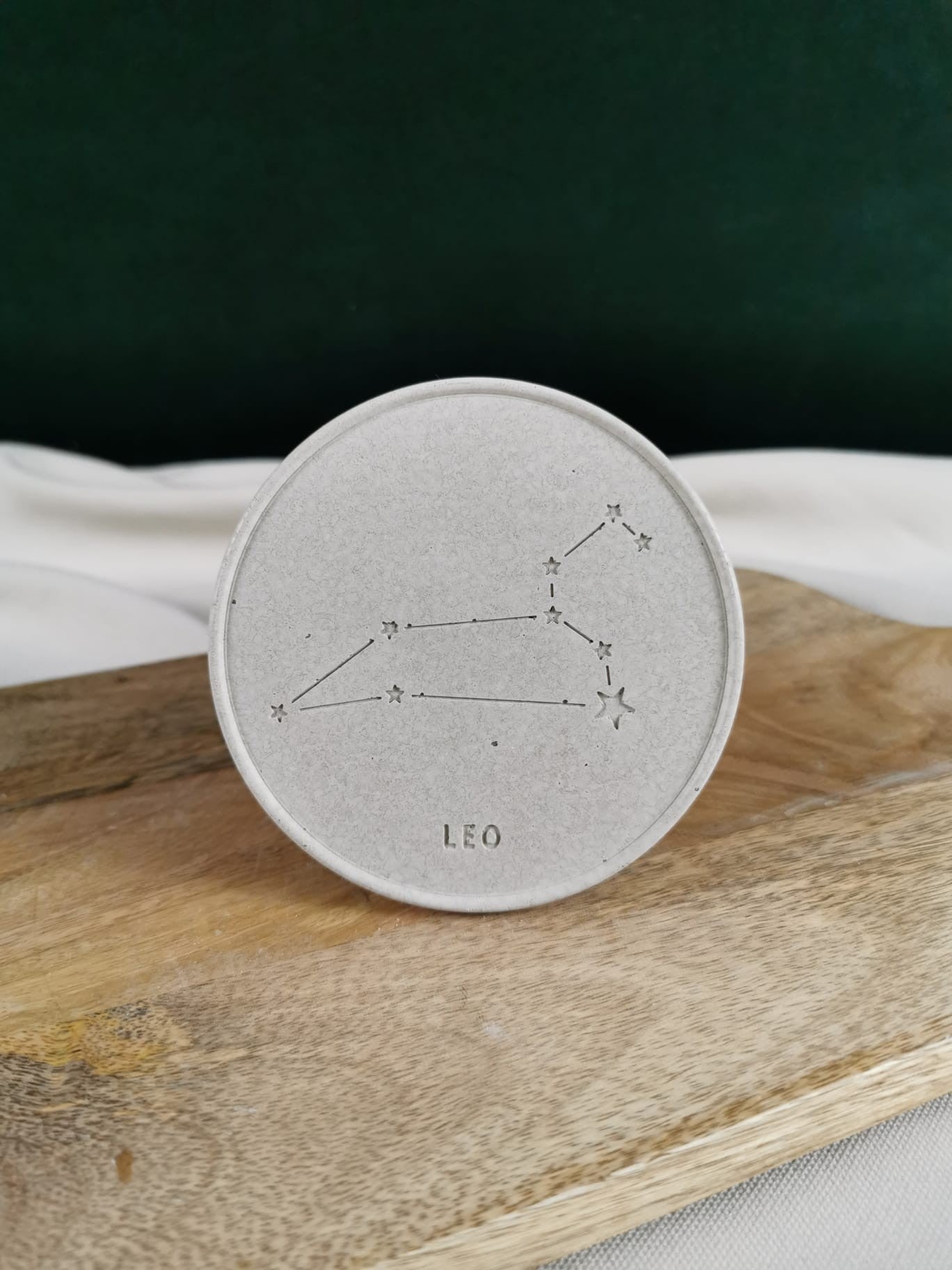 Handgefertigte minimalistische Seifenschale aus Beton in hellgrauer Farbe, modern strukturiert, liegend auf einem Holzbrett – ideal für Badezimmer oder Küche.