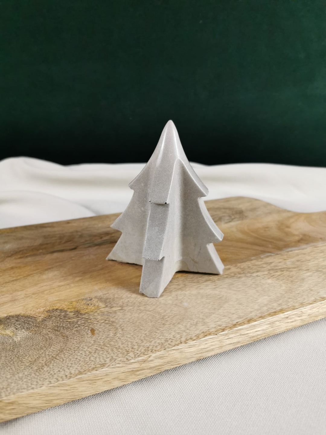 „Handgefertigter Beton-Tannenbaum in modernem Design auf Holzuntergrund – minimalistische Weihnachtsdeko aus Beton.“