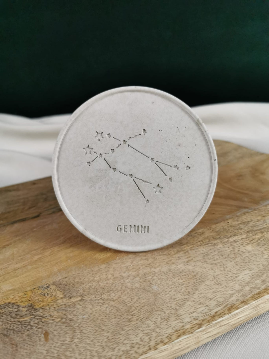Handgefertigter grauer Beton-Untersetzer mit eingraviertem Sternzeichen Gemini (Zwillinge) und filigraner Sternbild-Illustration.