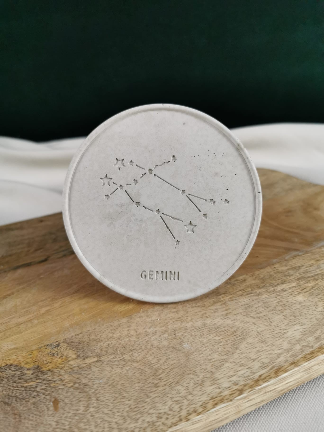 Handgefertigter grauer Beton-Untersetzer mit eingraviertem Sternzeichen Gemini (Zwillinge) und filigraner Sternbild-Illustration.