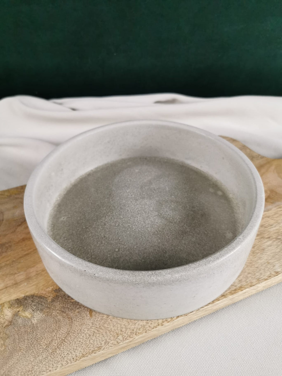 Handgemachte minimalistische Betonschale in hellem Grau, dekorativ auf einem Holzbrett präsentiert – perfekt für Schmuck, Deko, Räucherungen oder Kerzen.