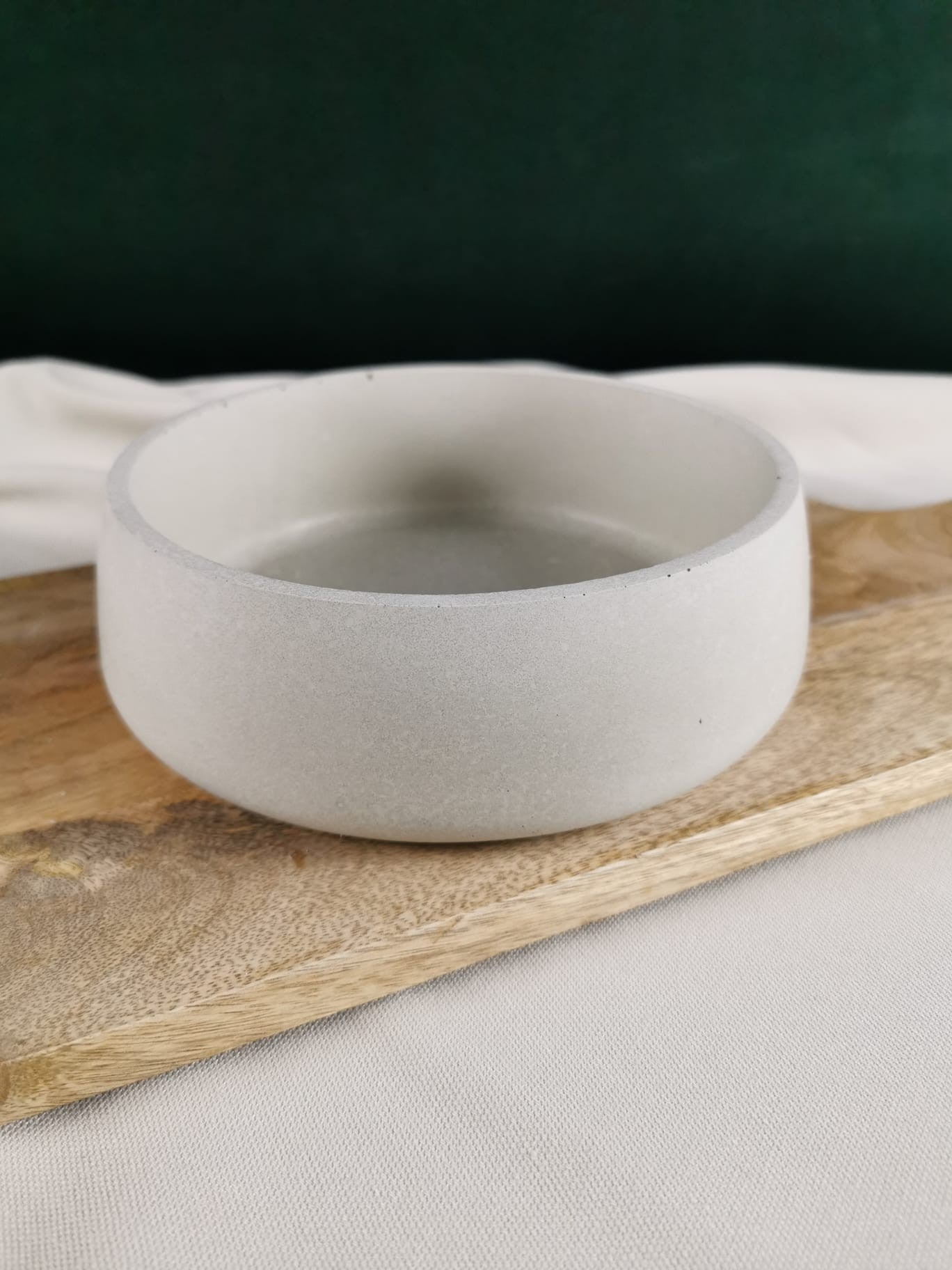 „Handgefertigte minimalistische Betonschale in naturgrau, dekorativ auf Holzunterlage präsentiert – moderne Deko- und Aufbewahrungsschale.“