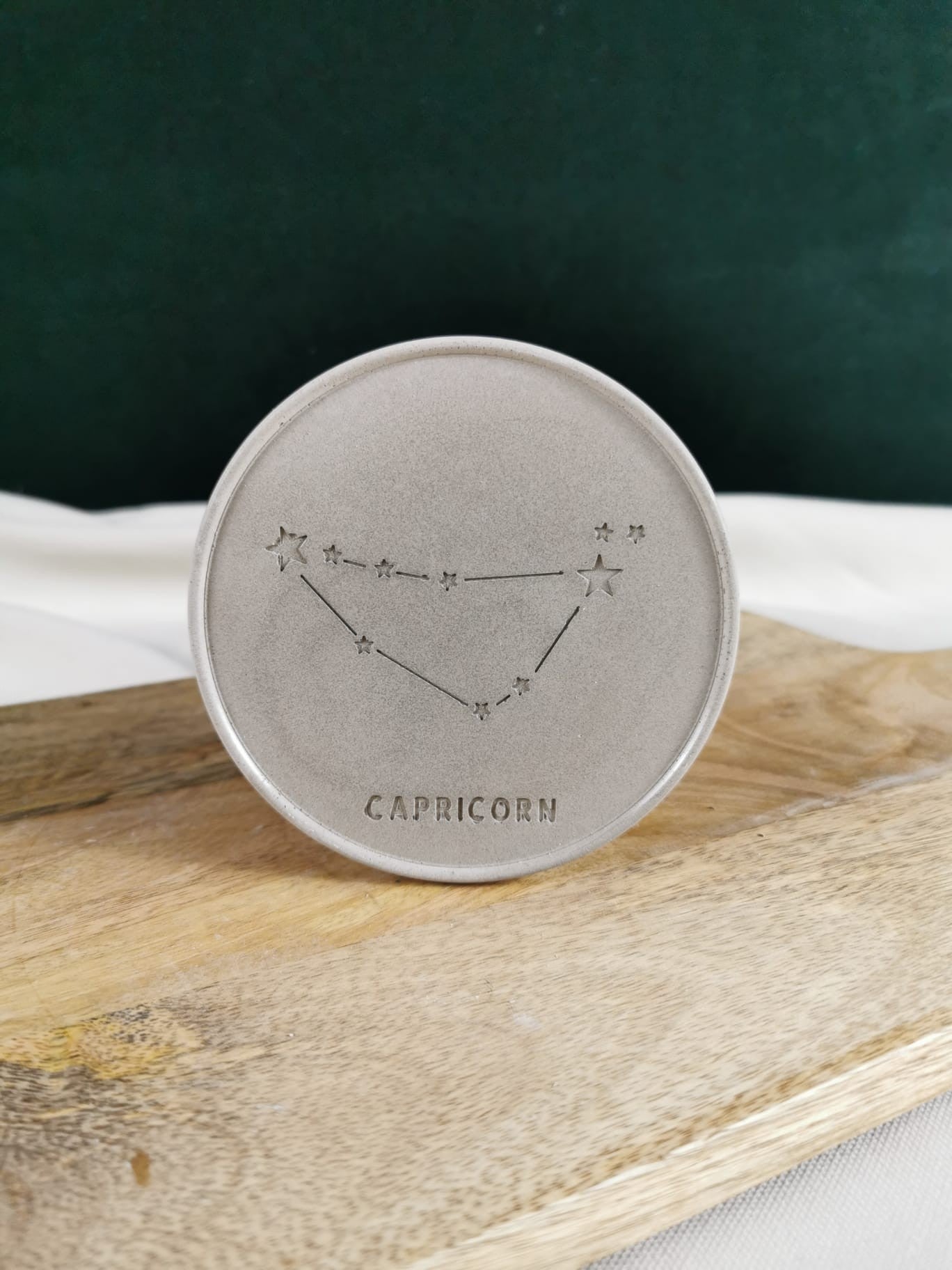 „Handgefertigter Beton-Untersetzer mit eingraviertem Capricorn/Steinbock-Sternbild – minimalistisches, modernes Dekoelement aus Beton.“