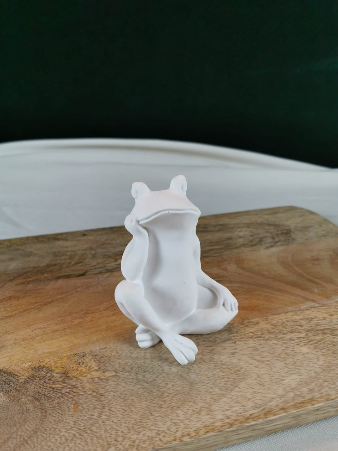 „Weiße sitzende Froschfigur auf Holzuntergrund – moderne handgefertigte Tierdeko.“