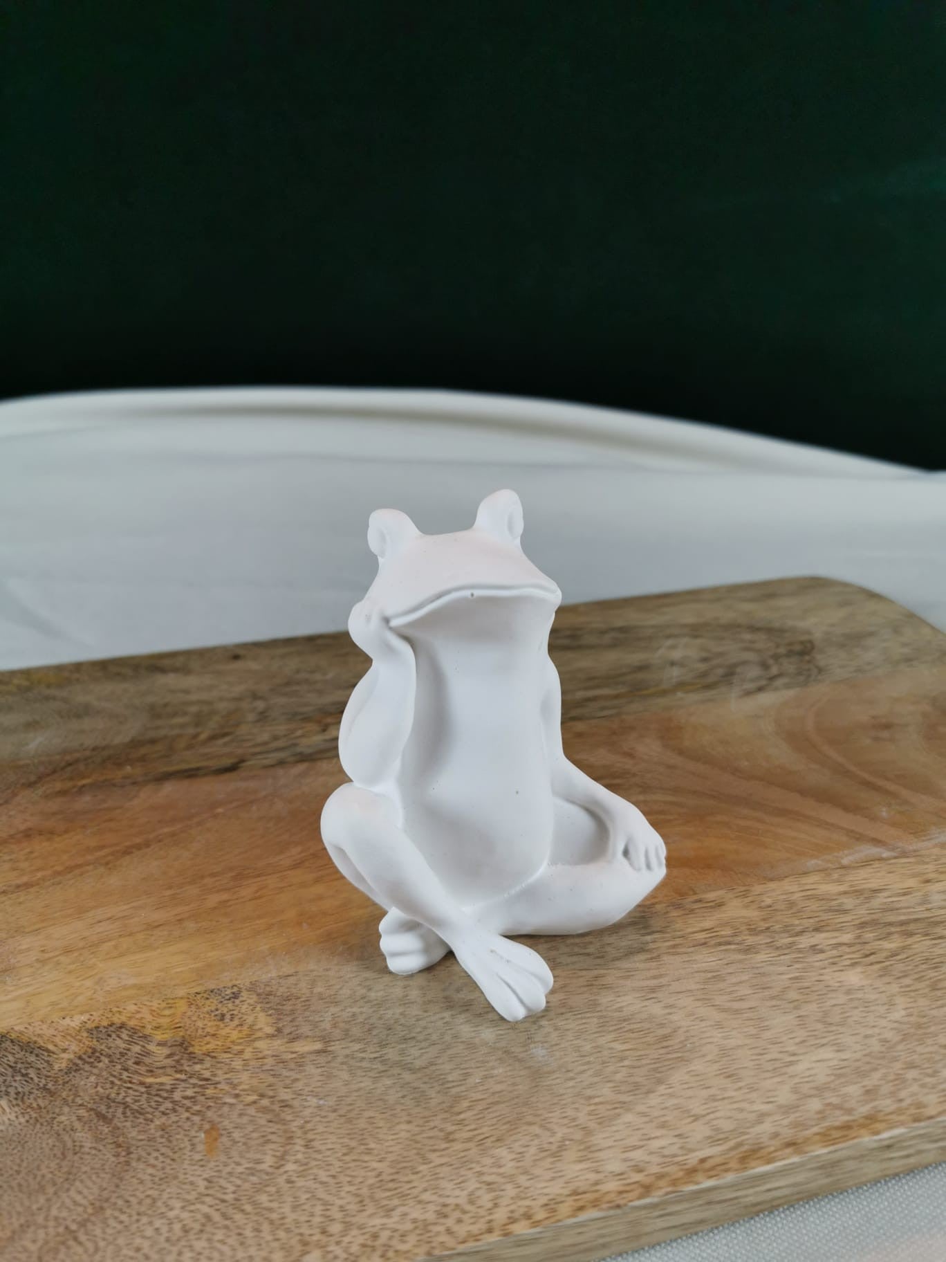 „Weiße sitzende Froschfigur auf Holzuntergrund – moderne handgefertigte Tierdeko.“