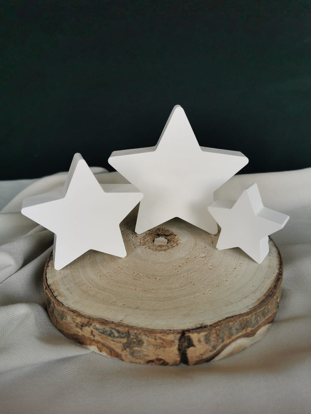 3 weiße Deko-Sterne aus Gips als 3er-Set auf Holzpodest – minimalistische Weihnachtsdeko