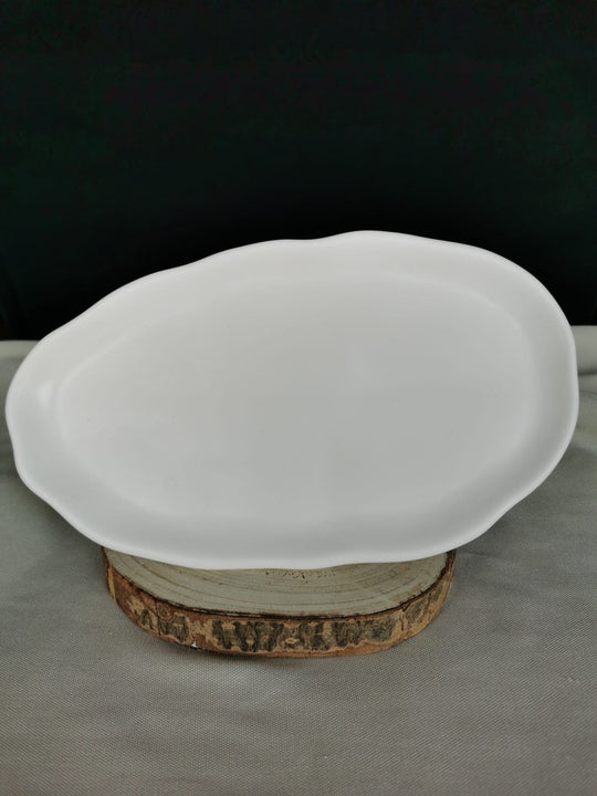 Weiße, handgefertigte flache Keramikschale mit organisch geformtem Rand, auf Holzuntergrund – minimalistisches Dekotablett für moderne Wohnräume quer