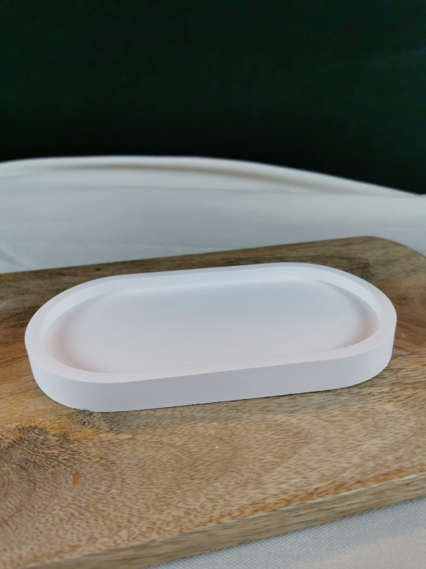 Weiße minimalistische Keramikschale in ovaler Form auf Holzuntergrund – dekorative Ablage für Schmuck, Kerzen und Deko.