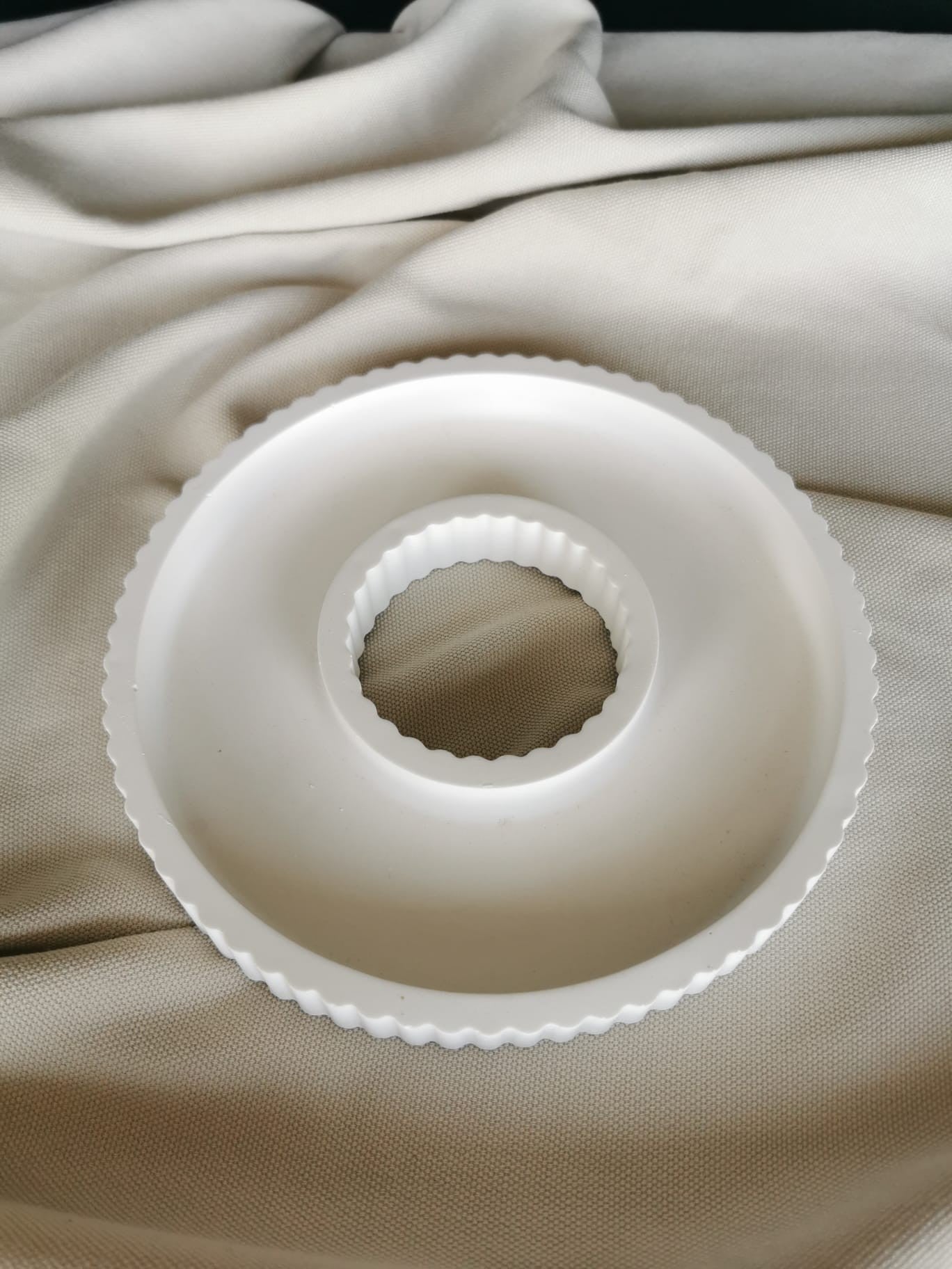 Runde Dekoform in weißer Keramik-Optik, geeignet für Mini-Häuschen und weihnachtliche Arrangements, fotografiert auf Stoffuntergrund.