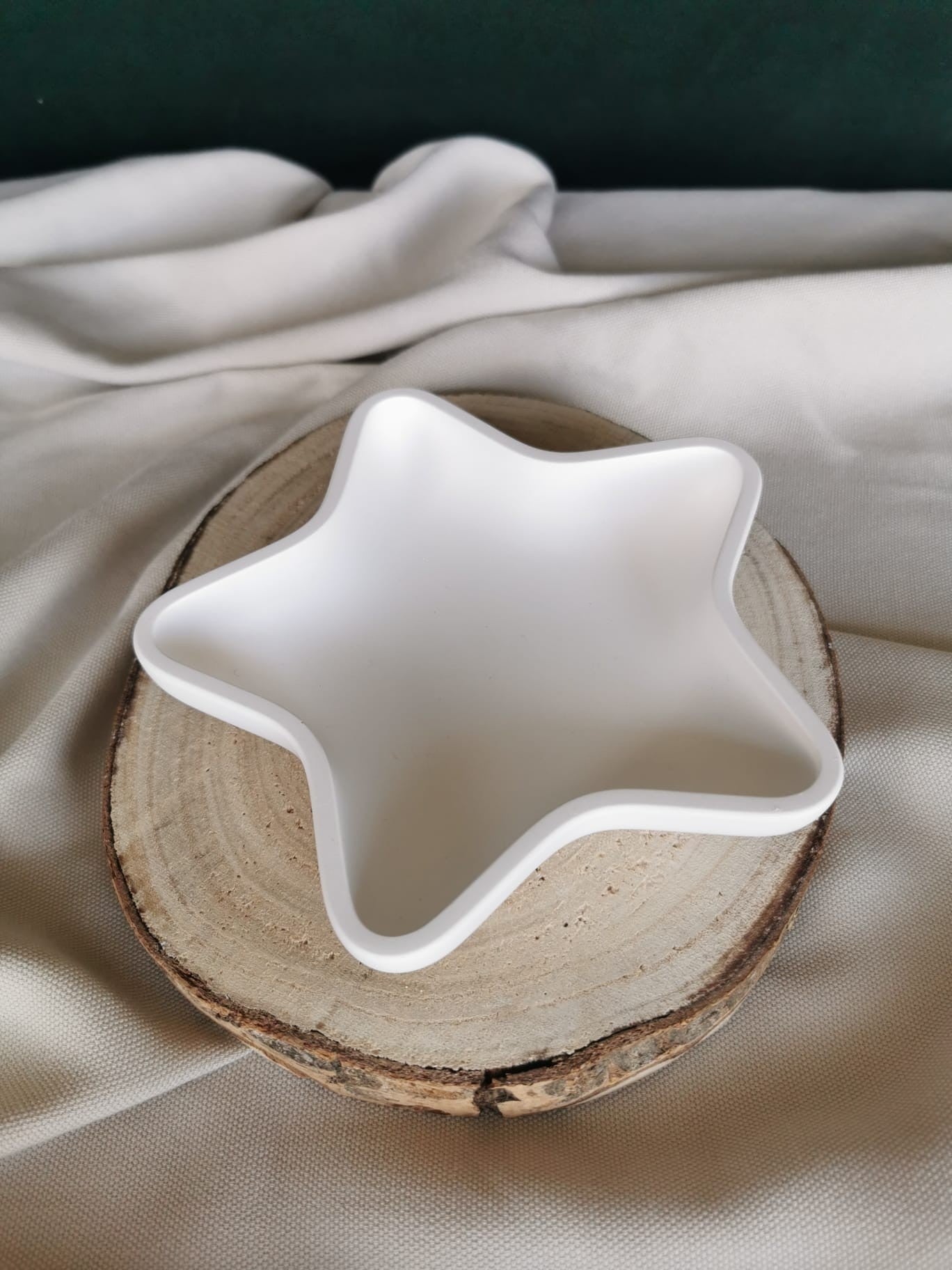 Weiße Keramik Stern-Schale als weihnachtliche Deko- und Ablageschale auf Holzuntergrund