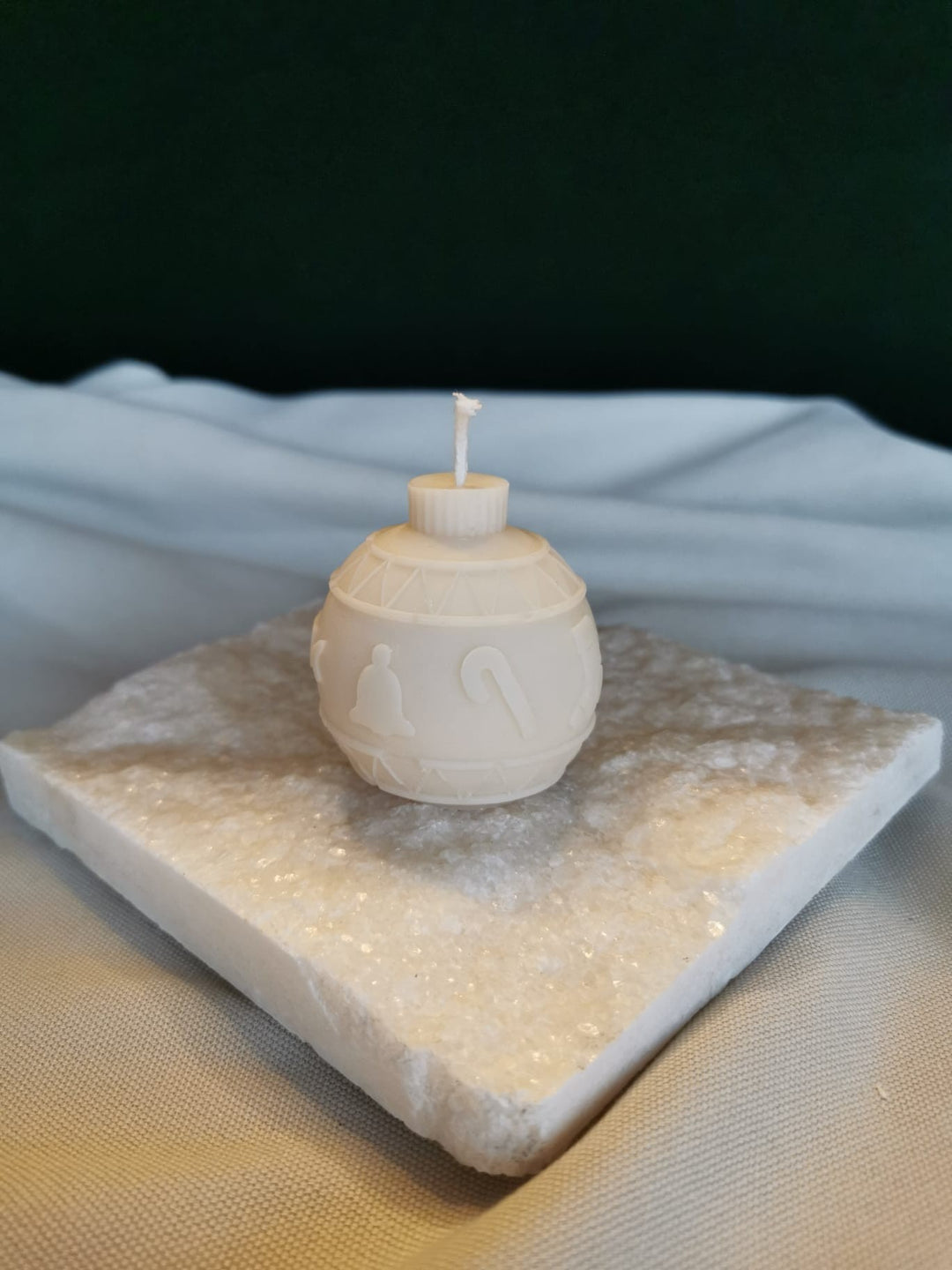 „Handgemachte Mini Weihnachtskugel Kerze aus weißem Rapswachs auf dekorativer Steinplatte – nachhaltige Winter- und Weihnachtsdekoration“