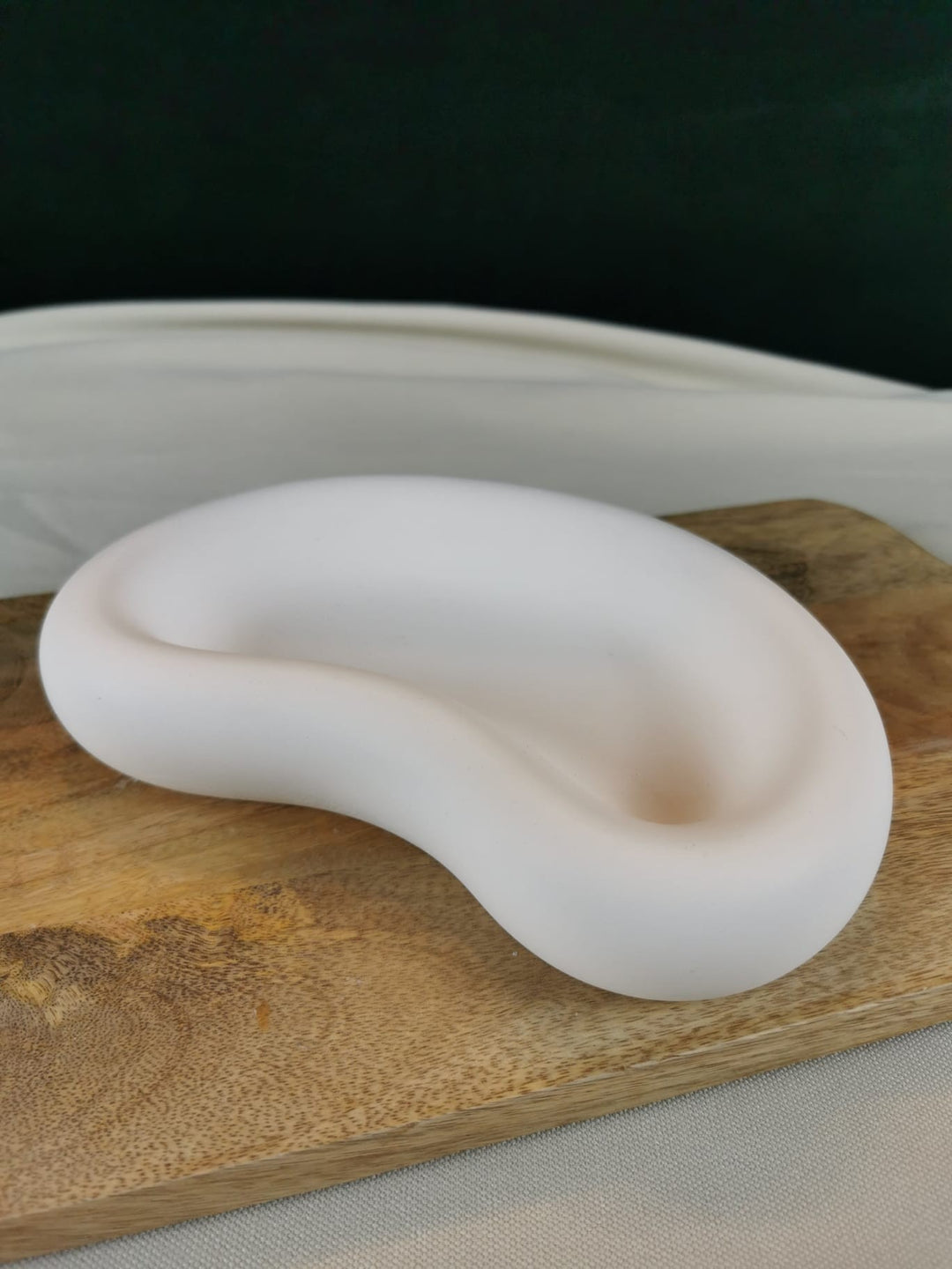 „Handgemachte organische Beton-Deko-Schale in fließender Form auf Holzunterlage – minimalistische Wohnaccessoire Schale in Weiß“