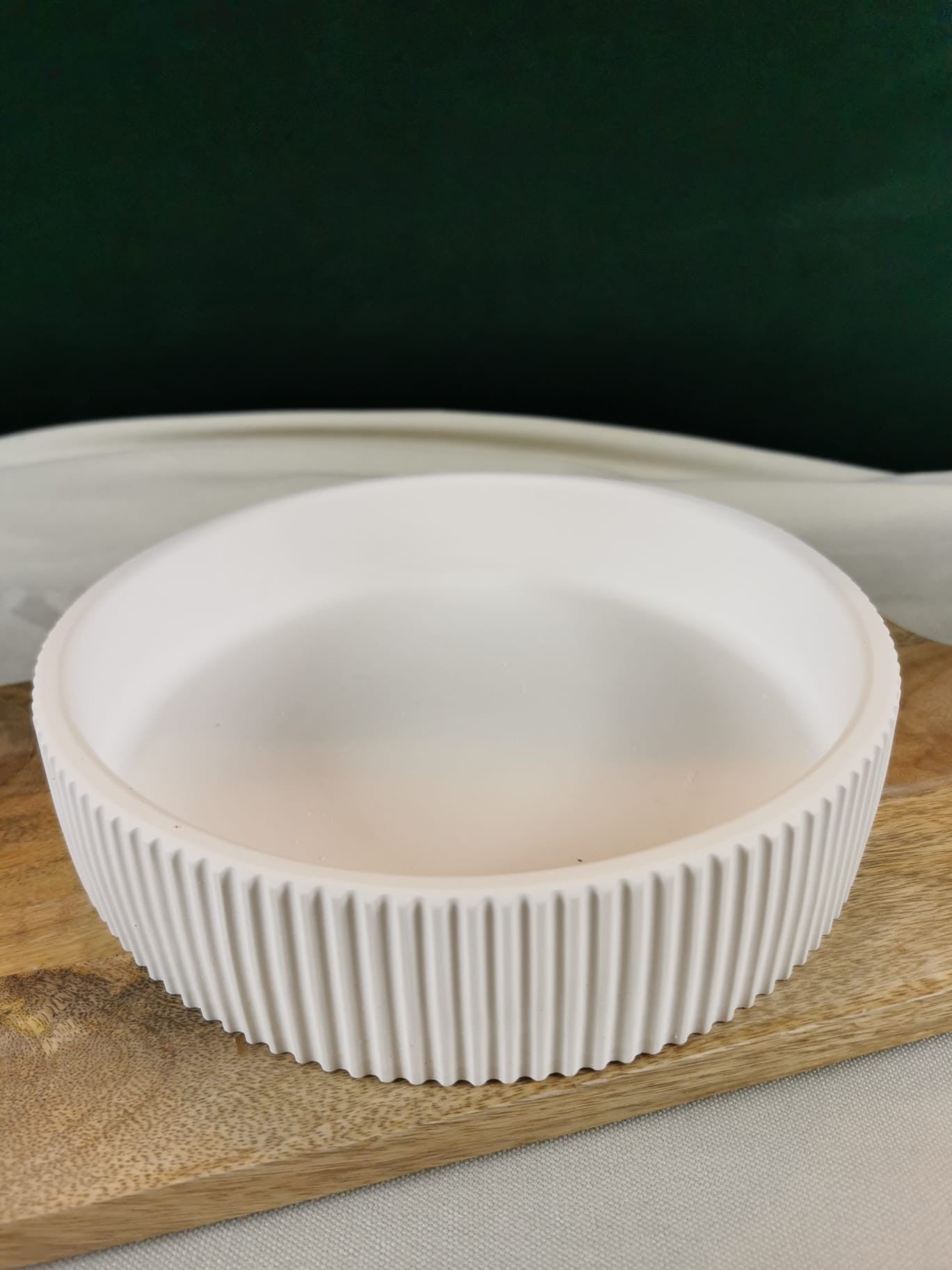 Handgefertigte organische Beton-Deko-Schale in geschwungener Form auf Holzuntergrund – minimalistisches Wohnaccessoire.