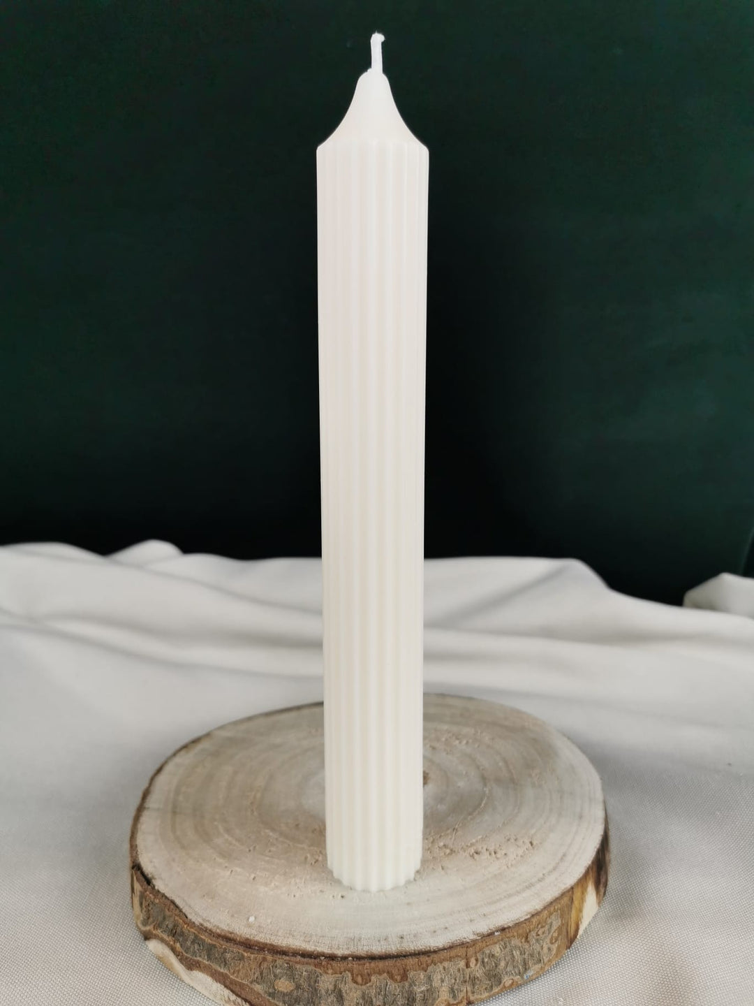 „Handgegossene weihnachtliche Ornament-Stabkerze aus cremefarbenem Rapswachs mit filigranem Vintage-Schneeflocken-Design auf marmorierter Unterlage.“