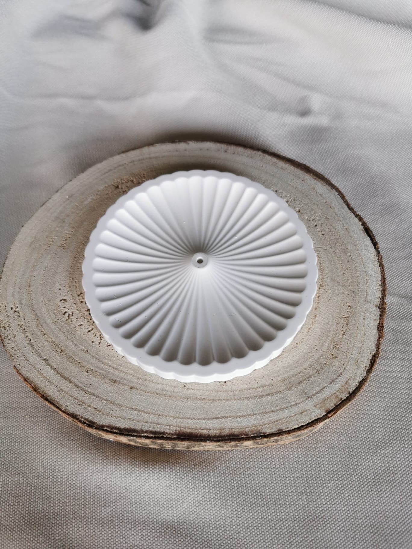 Weißer, handgefertigter Räucherstäbchenhalter aus Keramik mit strukturierter Oberfläche, platziert auf Holzuntergrund – minimalistisches, achtsames Wohnaccessoire