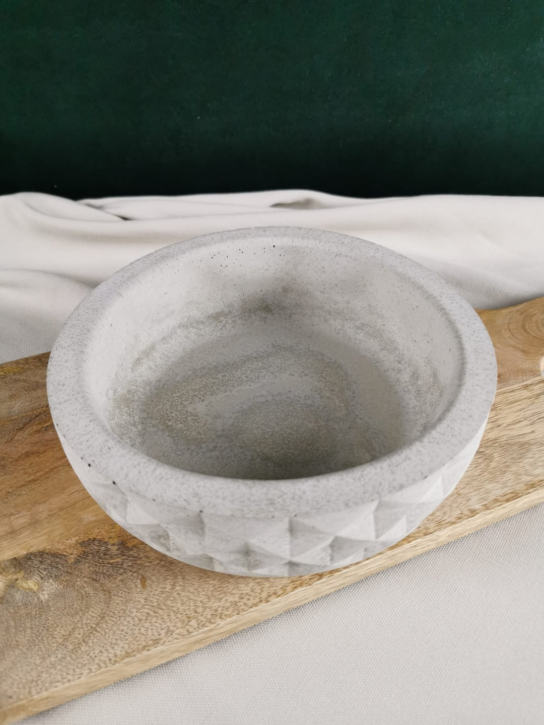 Handgegossene Weihnachtsbaum-Kerze aus natürlichem Rapswachs in Cremeweiß auf Deko-Steinplatte – detailreich, geriffelt und winterlich.