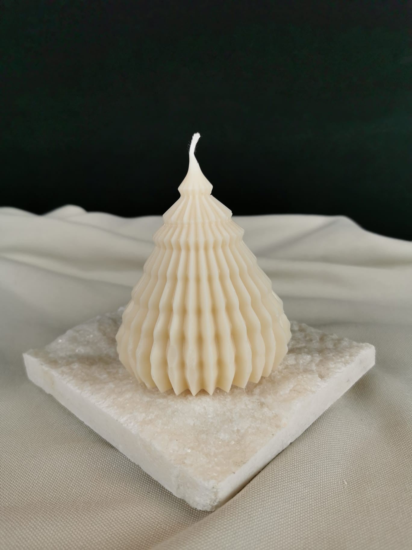 „Handgemachte Rillen-Tannenbaum Kerze aus naturfarbenem Bio-Rapswachs auf Steinplatte, dekorative Winterkerze.“
