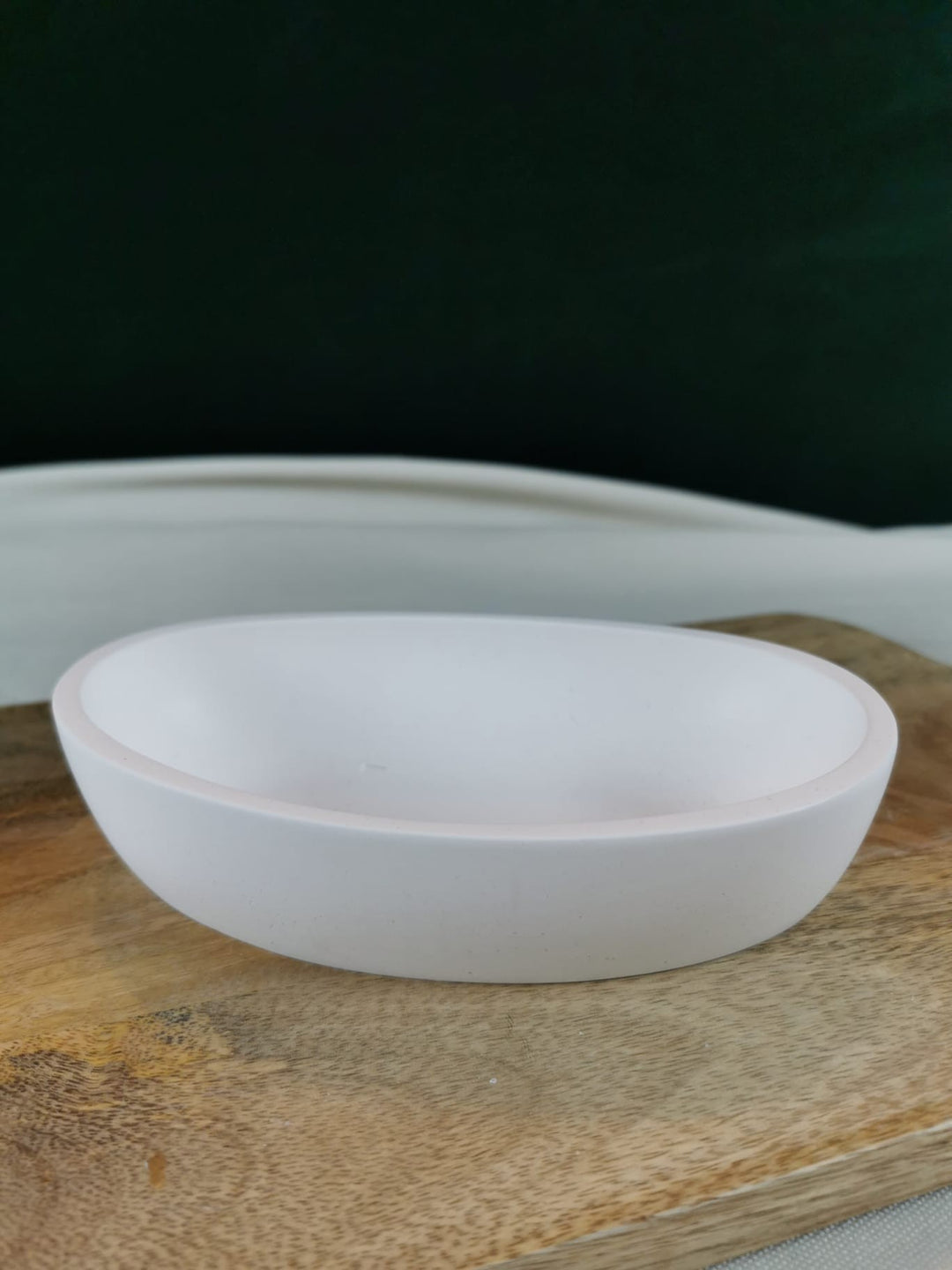 „Runde weiße Dekoschale auf Holzuntergrund – minimalistische handgefertigte Wohndekoration.“