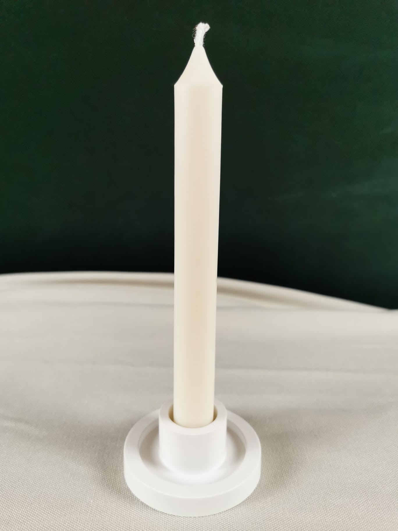 „Handgemachte elegante Stabkerze aus natürlichem Rapswachs in Cremeweiß, minimalistisch und modern, stehend in einem schlichten Kerzenhalter.”