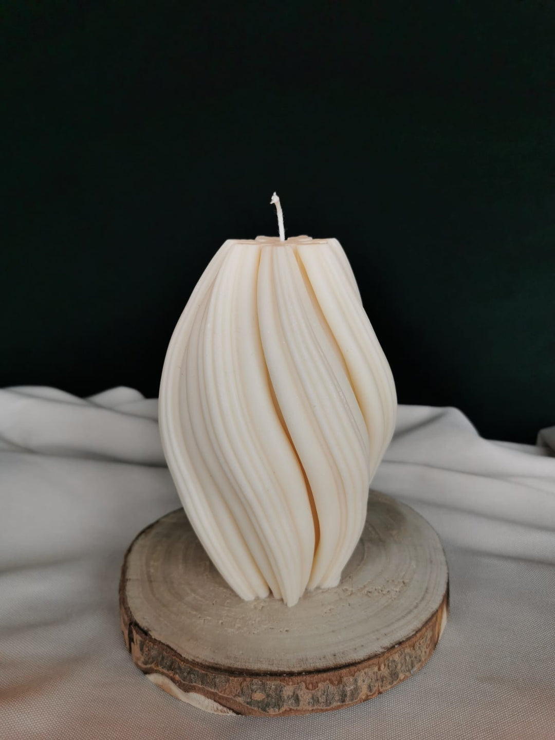 „Gedrehte Twist Design Kerze aus hellem Rapswachs auf Holzunterlage – handgegossene minimalistische Deko.“