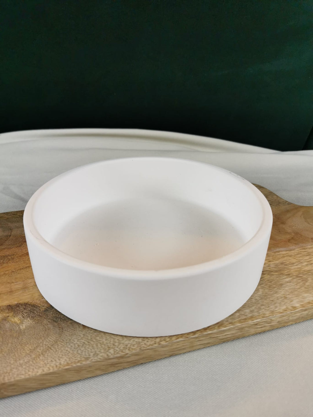 „Runde weiße Dekoschale auf Holzuntergrund – moderne handgefertigte Ablageschale.“