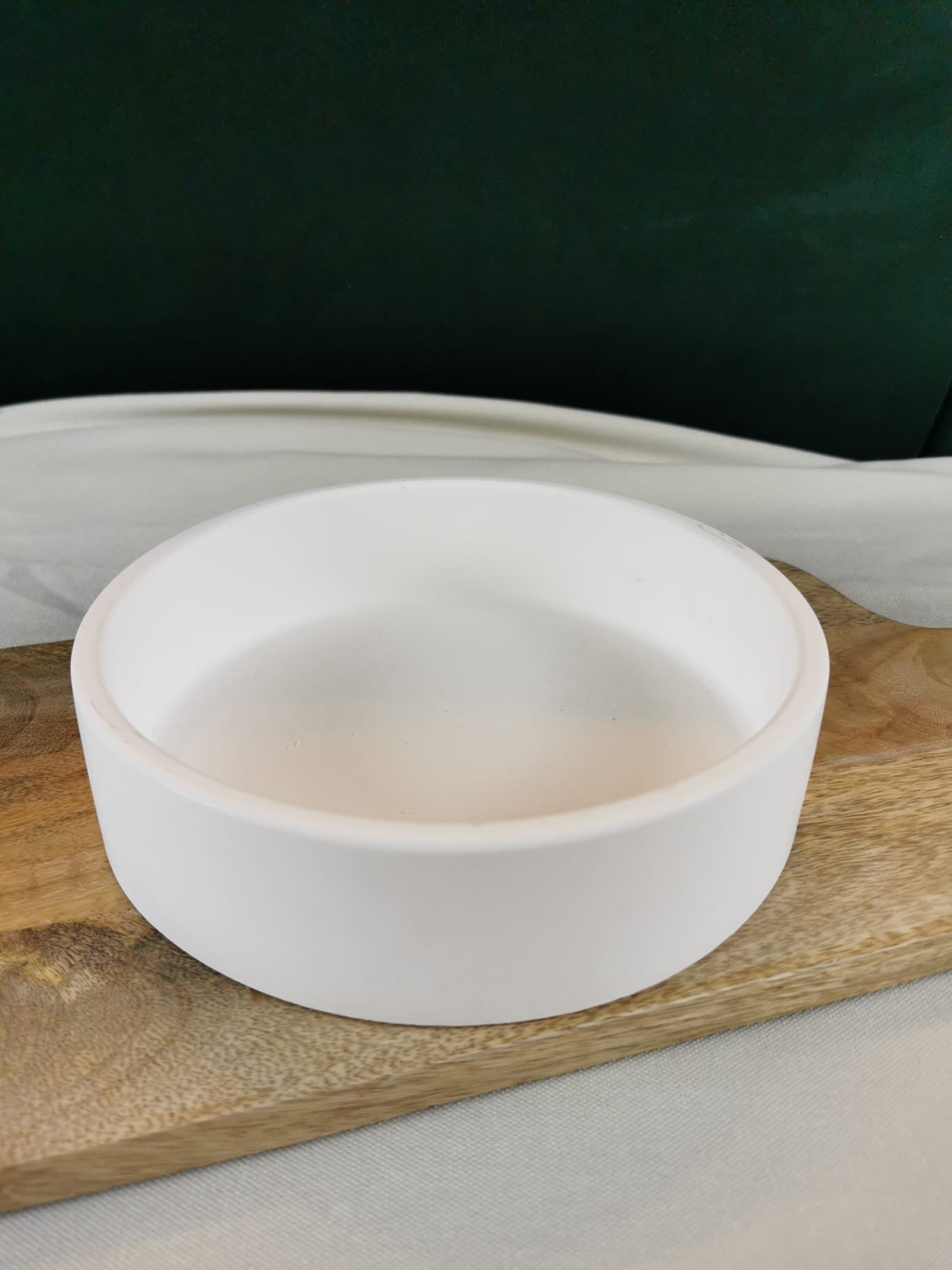 „Runde weiße Dekoschale auf Holzuntergrund – moderne handgefertigte Ablageschale.“