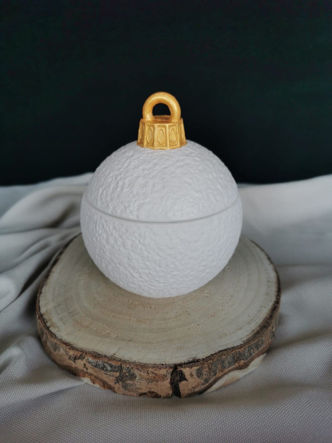 Handgemachte weiße Weihnachtskugel-Kerze aus Sojawachs mit goldfarbenem Deckel und Holzdocht – dekorative Winter Duftkerze.