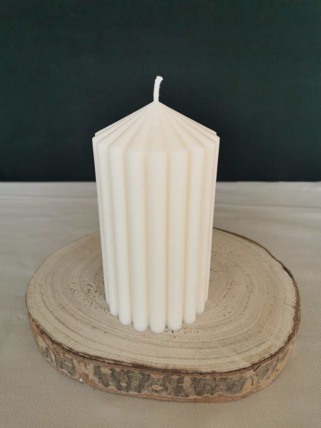 Handgemachte weiße Rillen-Stumpenkerze aus Rapswachs – elegante Deko Kerze auf Holzunterlage