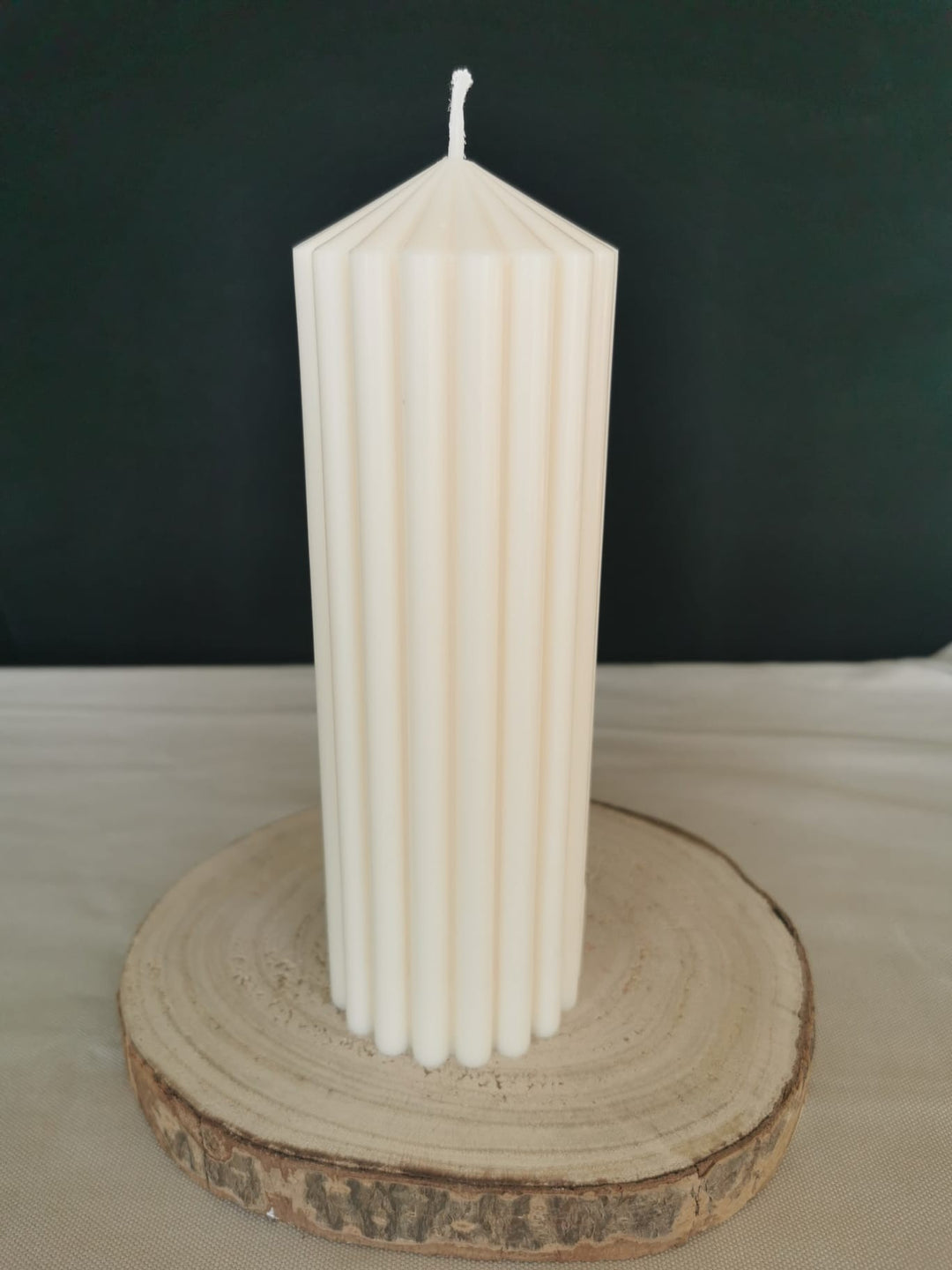 “Weiße Rillenkerze auf Holzbrett – elegante handgemachte Deko-Kerze für Winter und Weihnachten”